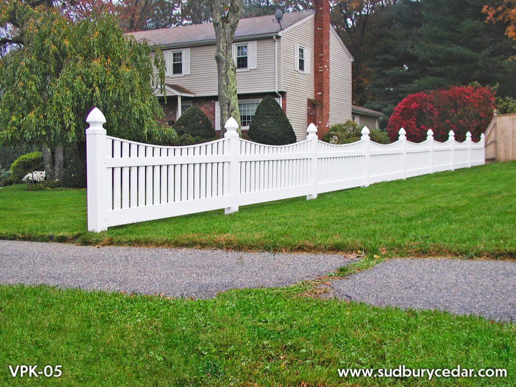 Classic white vinyl picket fence installed along landscaped residential front yard in Massachusetts.