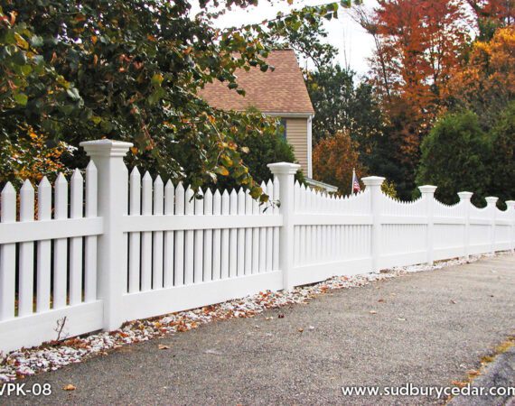 Curved white vinyl scalloped picket fence installed along landscaped residential property in Maynard, Massachusetts.