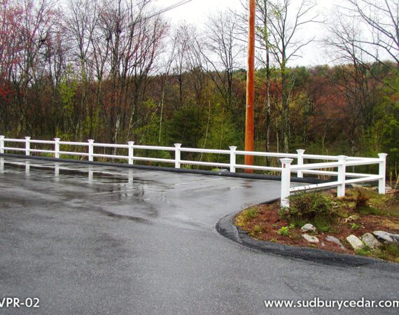White vinyl post and rail fence installed along curved residential driveway and landscaped property in Stow, Massachusetts.