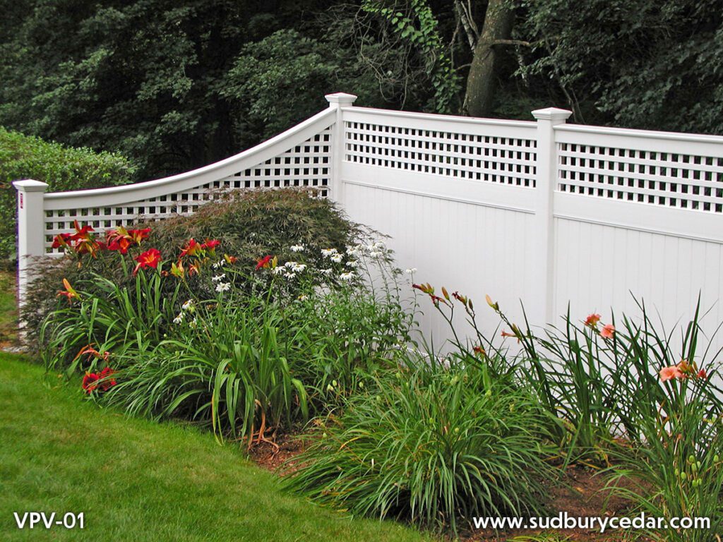 White vinyl privacy fence with lattice top and lush landscaping by Sudbury Cedar Fence Co., in Hudson, MA.