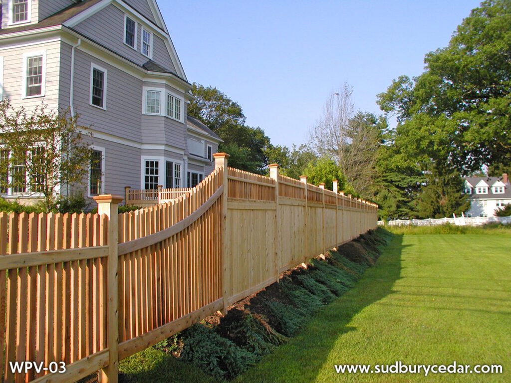 Cedar privacy fence with picket top detail along residential property in Concord, MA.