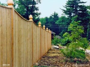 Scalloped cedar privacy fence with vertical boards and landscaped surroundings in Acton, MA