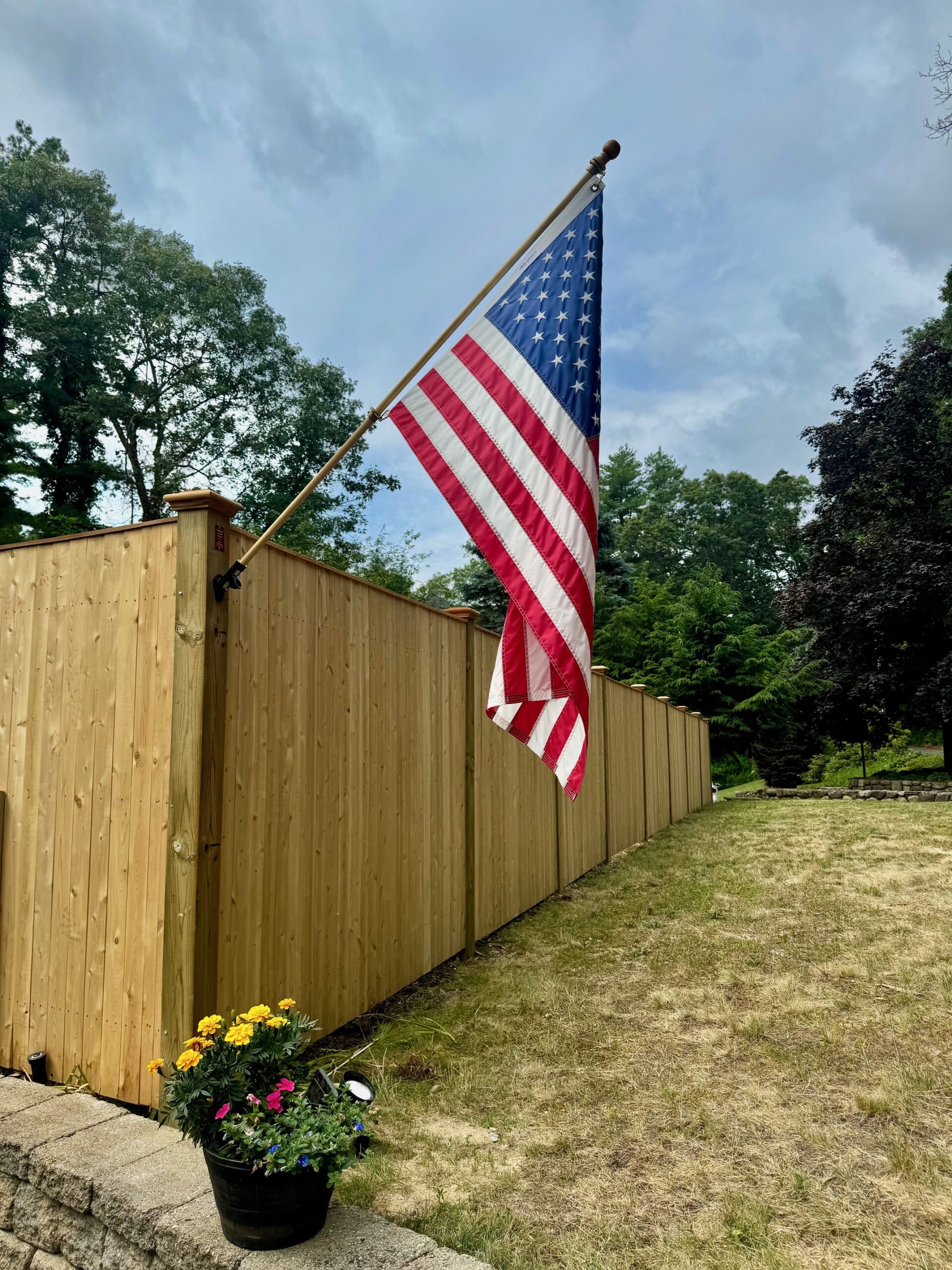 A US flag adorns a Cedar board fence by Sudbury Cedar Fence Co in Hudson MA