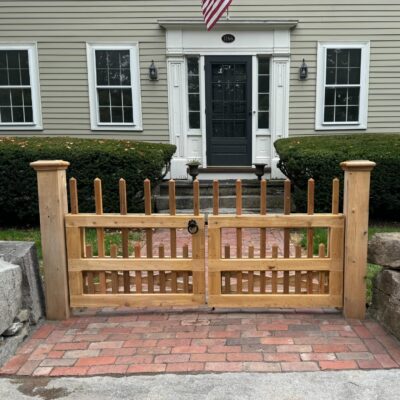 Custom cedar double swing picket gate with black hardware at front entry walkway in Concord Massachusetts