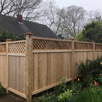 Northern white cedar privacy fence with lattice top at corner of residential yard with garden landscaping in Stow Massachusetts
