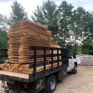 Stacked northern white cedar fence boards and posts on delivery truck in Massachusetts showing quality wood materials for fencing