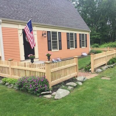 Northern white cedar picket fence surrounding front yard with garden and walkway in Concord Massachusetts