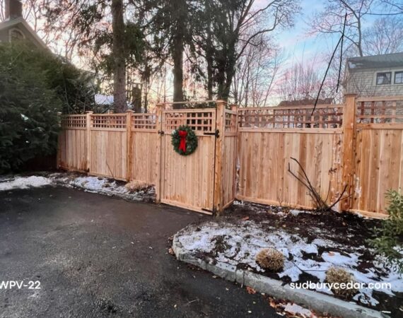 Decorative cedar privacy fence with square lattice top and custom double gates installed along a driveway in Concord, MA