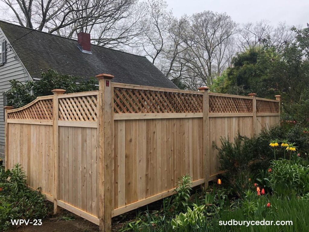 Cedar privacy fence with lattice top and wood posts in landscaped yard in Stow, MA.