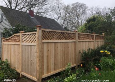 Cedar privacy fence with lattice top and wood posts in landscaped yard in Stow, MA.