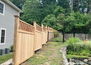Cedar privacy fence following slope with lattice top and transition to metal fence in Wayland, MA