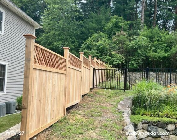 Cedar privacy fence following slope with lattice top and transition to metal fence in Wayland, MA