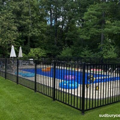 Black ornamental aluminum fence enclosing a residential swimming pool with open sightlines and decorative finial accents