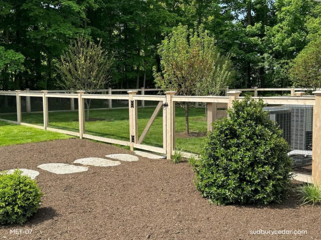 Cedar post and wire fence with matching gate enclosing a landscaped backyard in Concord, Massachusetts