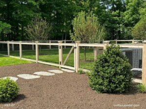 Cedar post and wire fence with matching gate enclosing a landscaped backyard in Concord, Massachusetts