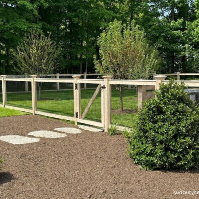 Cedar post and wire fence with matching gate enclosing a landscaped backyard in Concord, Massachusetts