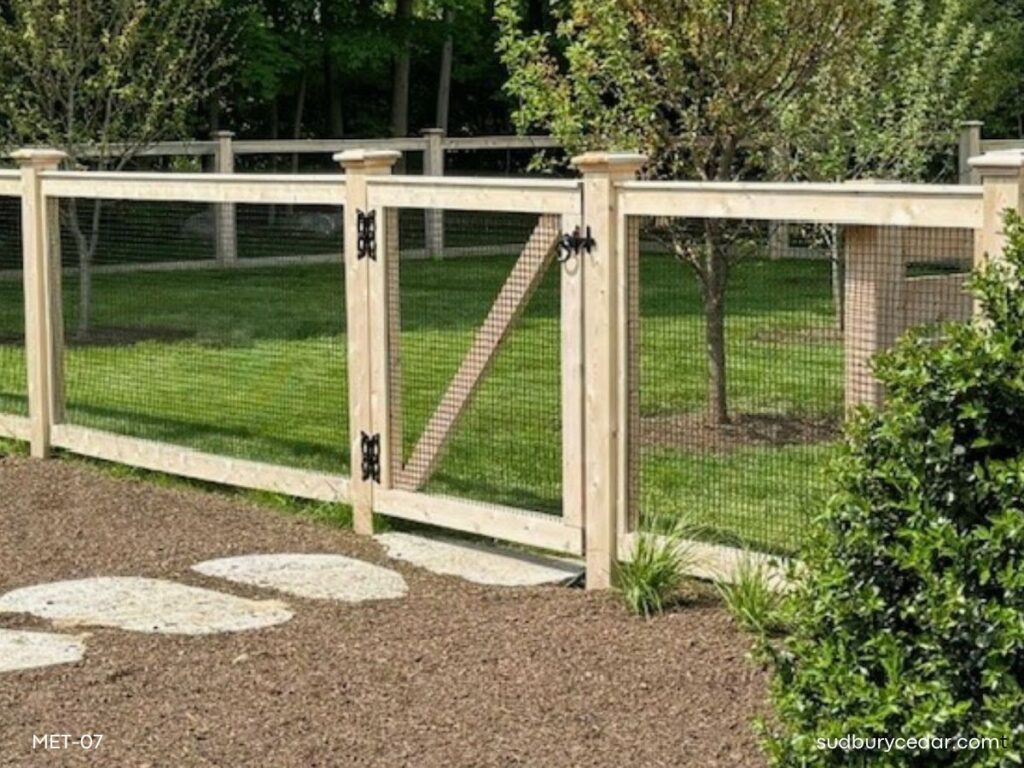 Cedar post and wire fence with matching gate enclosing a landscaped backyard in Concord, Massachusetts
