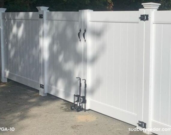 White vinyl double drive gate with decorative black hardware and matching vinyl privacy fencing installed in Wayland, Massachusetts driveway entrance.