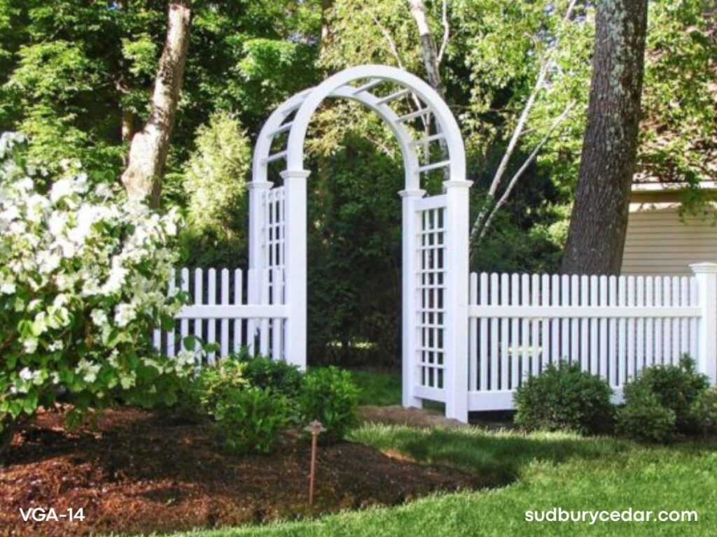 Decorative white vinyl arbor with lattice side panels and matching vinyl picket fencing installed in landscaped Weston, Massachusetts backyard.