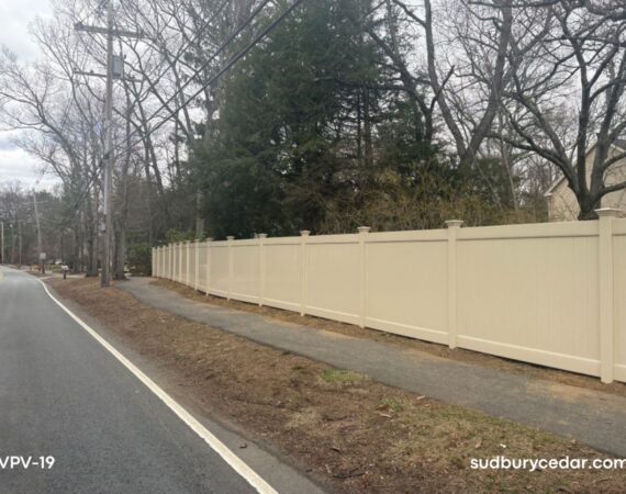 Almond vinyl privacy fence along roadway in Sudbury, Massachusetts