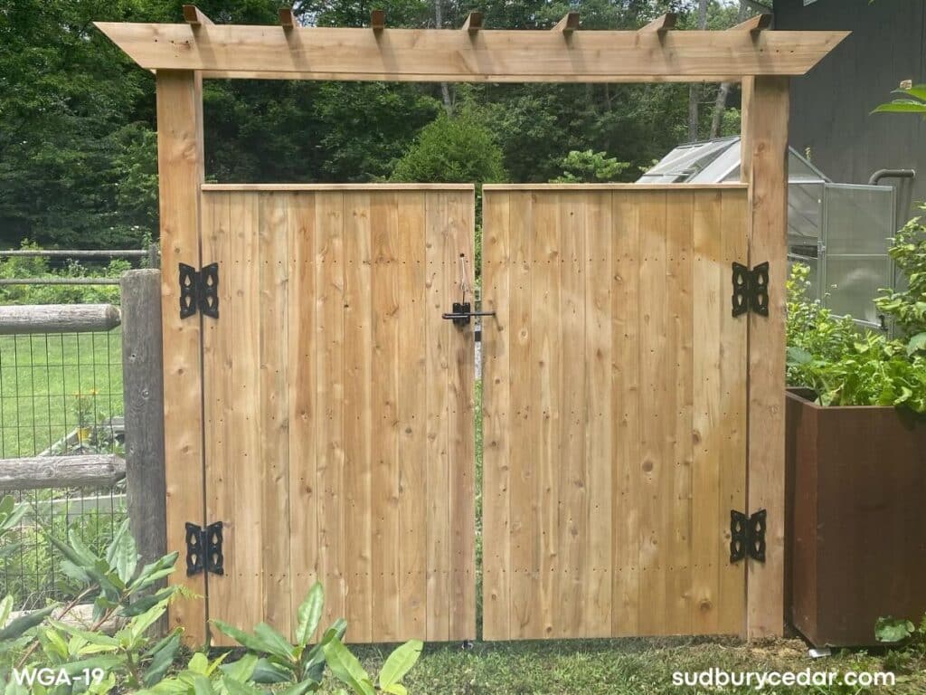 Custom cedar garden gate with pergola-style arbor and black decorative hardware installed in MetroWest Massachusetts