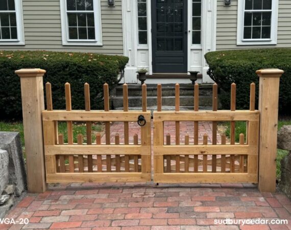Custom cedar entry gate with decorative picket detailing and oversized cedar posts installed at a brick walkway in Concord MA