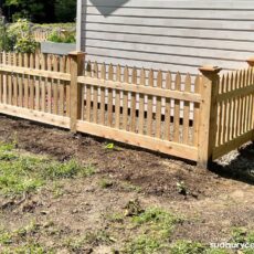 decorative cedar picket fence surrounding raised garden area in massachusetts