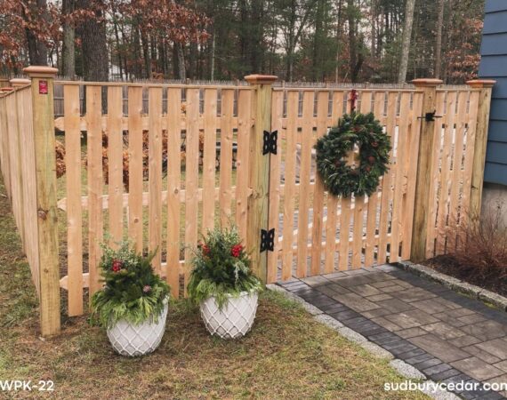 cedar spaced picket fence and gate installed beside backyard patio in sudbury massachusetts
