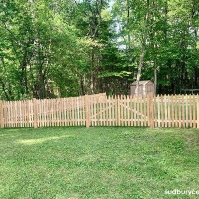 cedar picket fence installed along wooded backyard property in hudson massachusetts