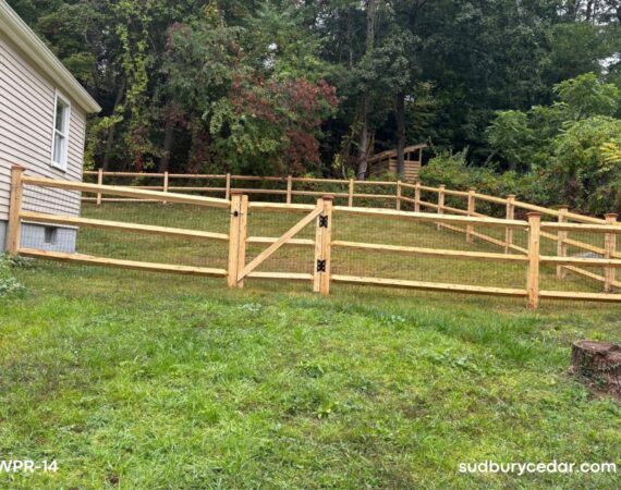 cedar post and rail fence with wire mesh and gate installed on sloped backyard in sudbury ma