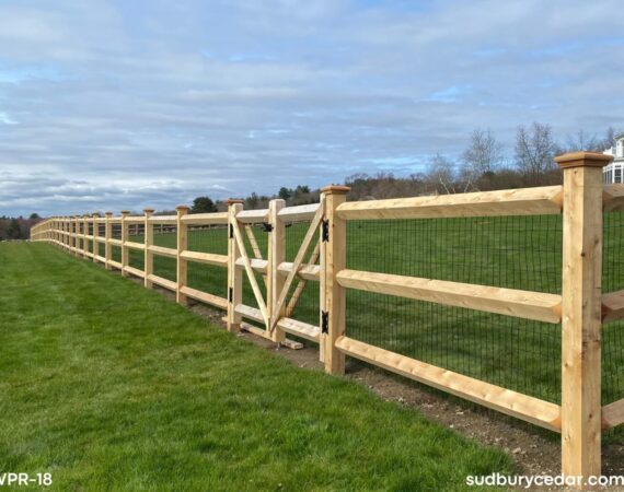 Custom cedar post and rail fence with wire mesh and gate installed for a large residential property in Harvard, Massachusetts.