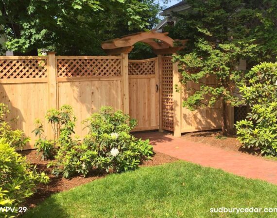 Custom decorative cedar privacy fence with pergola-style arbor creating an elegant backyard entry and outdoor living space in MetroWest Massachusetts.