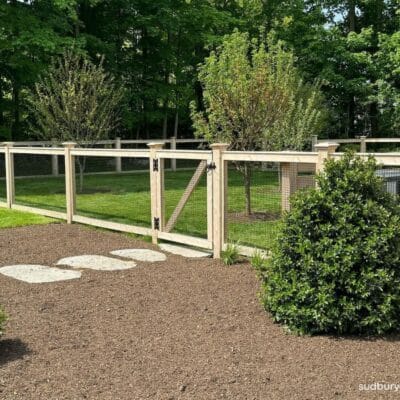 Cedar post and wire fence with matching gate enclosing a landscaped backyard in Concord, Massachusetts
