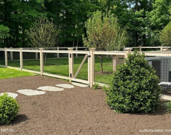 Cedar post and wire fence with matching gate enclosing a landscaped backyard in Concord, Massachusetts