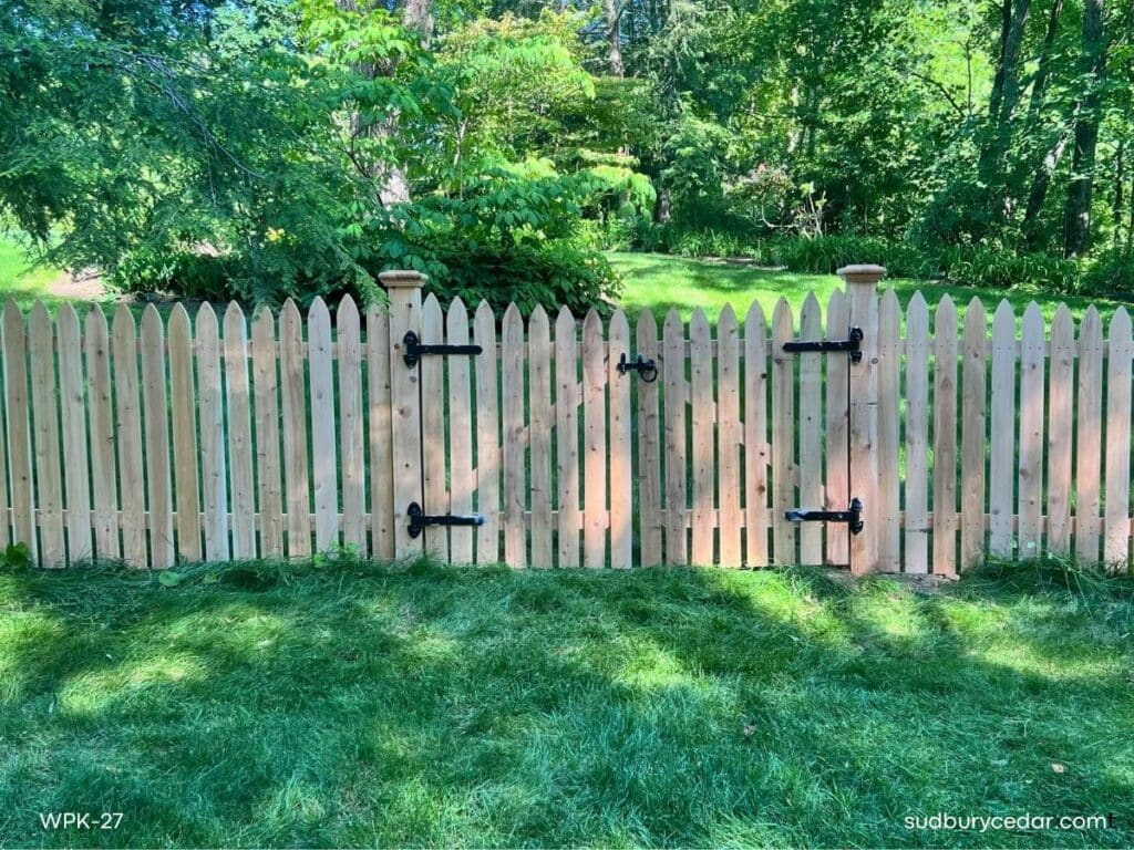 Custom cedar picket fence gate installed on a wooded residential property in Lincoln, Massachusetts
