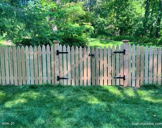 Custom cedar picket fence gate installed on a wooded residential property in Lincoln, Massachusetts
