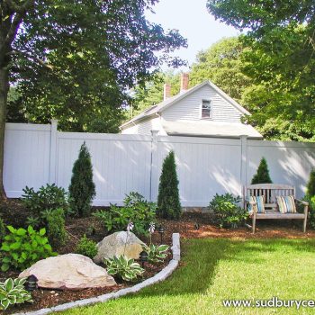 White vinyl privacy fence creating a clean, secluded backyard retreat in Maynard, Massachusetts.