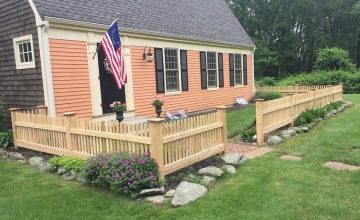 Northern white cedar picket fence surrounding front yard with garden and walkway in Concord Massachusetts