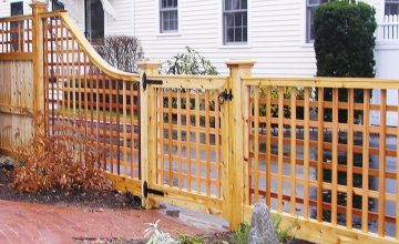 Custom cedar lattice gate and decorative privacy fence with curved lattice transition installed along a brick walkway in MetroWest Massachusetts